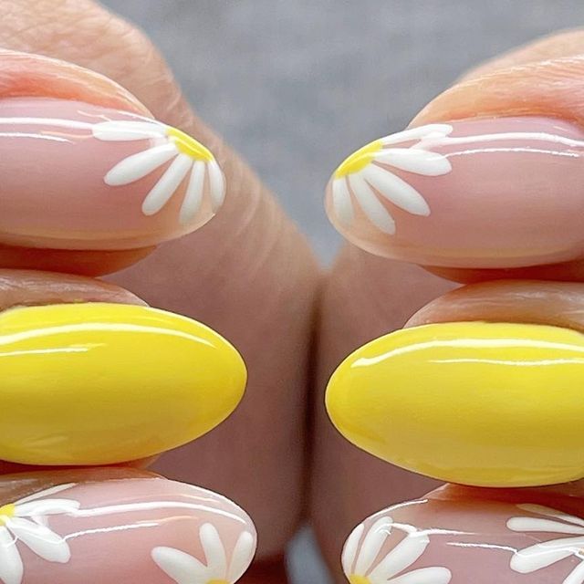 Spring-inspired Pastel Pink and Vibrant Yellow Nail Design with White Daisy Patterns.