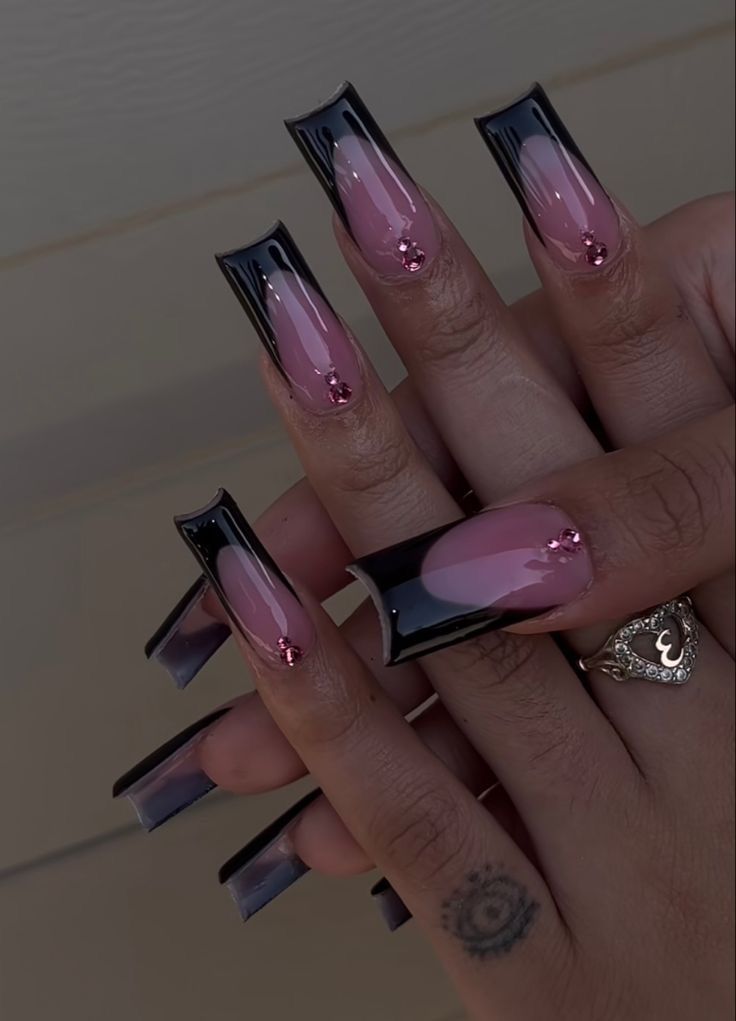 Trendy Black and Pink Acrylic Nail Design with Gemstone Accents.