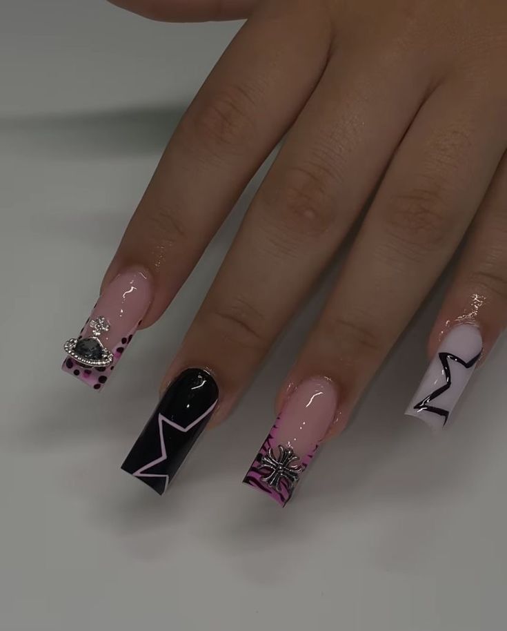 Captivating Nail Design with Pink and Black Hues, Intricate Patterns, and Glamorous Embellishments.