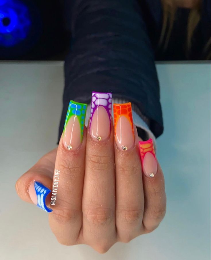 Vibrant Nail Art: Bold Geometric Designs with Neon Colors and Gemstone Accents.