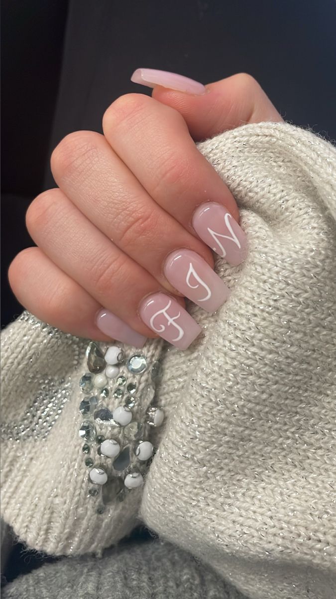 Elegant Long Pink Manicure Enhanced by Minimalist Lettering and Cozy Sweater