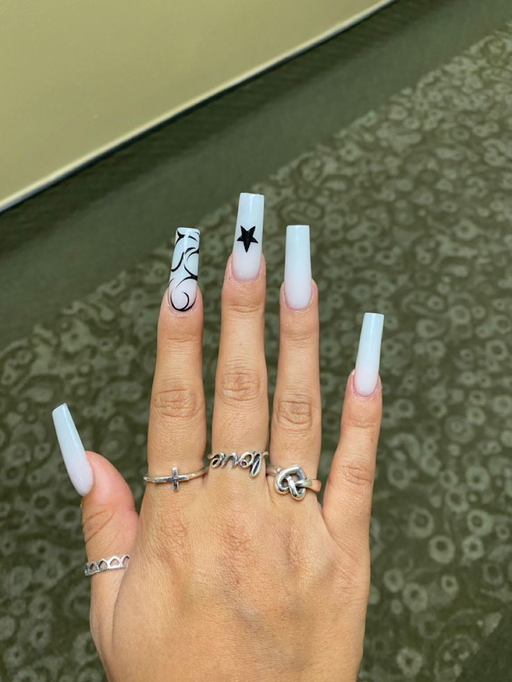 Chic White Ombre Long Nails with Elegant Black Floral Patterns and Star Accents for a Stylish Look.