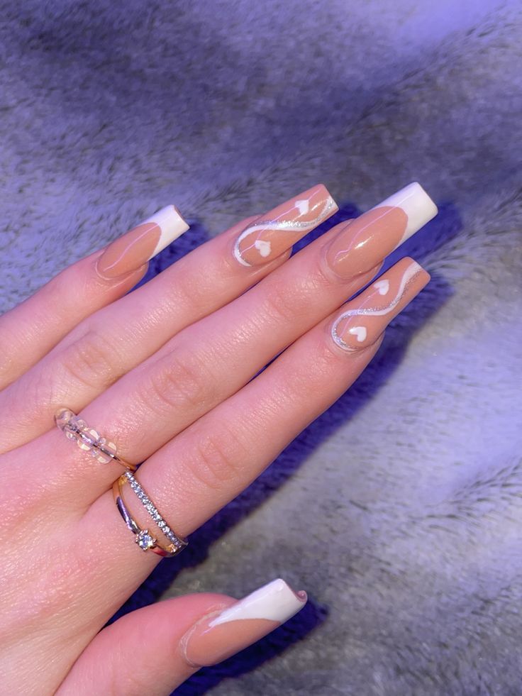 Sophisticated Whimsical Nail Design with Nude Base, White Swirls, and Heart Motifs.