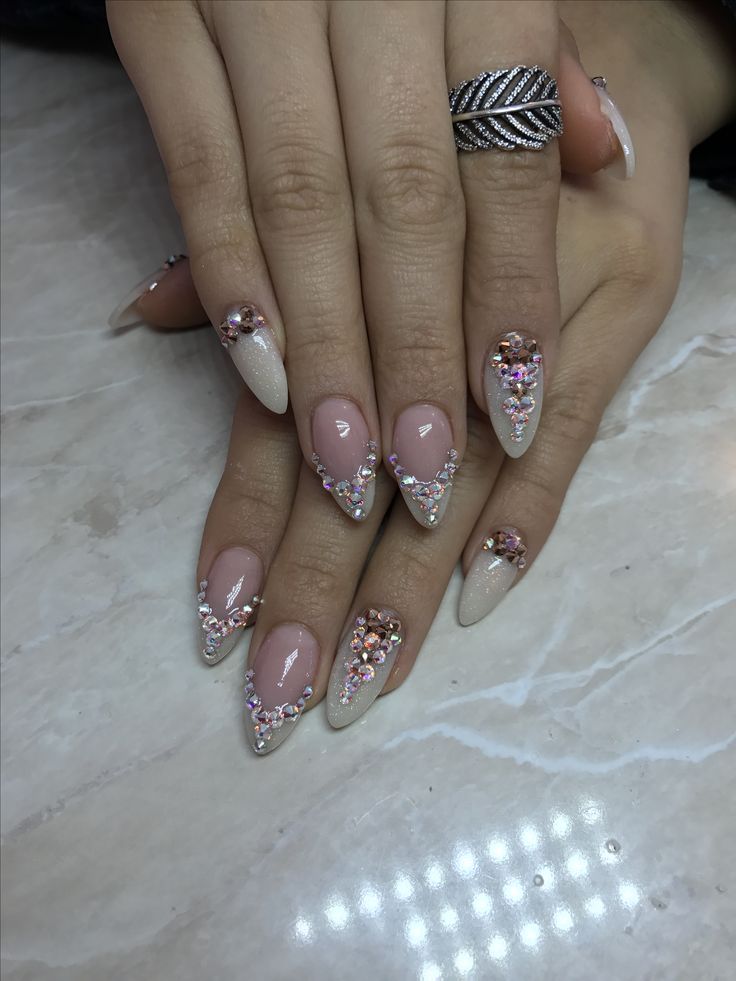 Elegant Glittering Nude and Beige Almond-Shaped Nail Design with Sparkling Gems and Sequins.