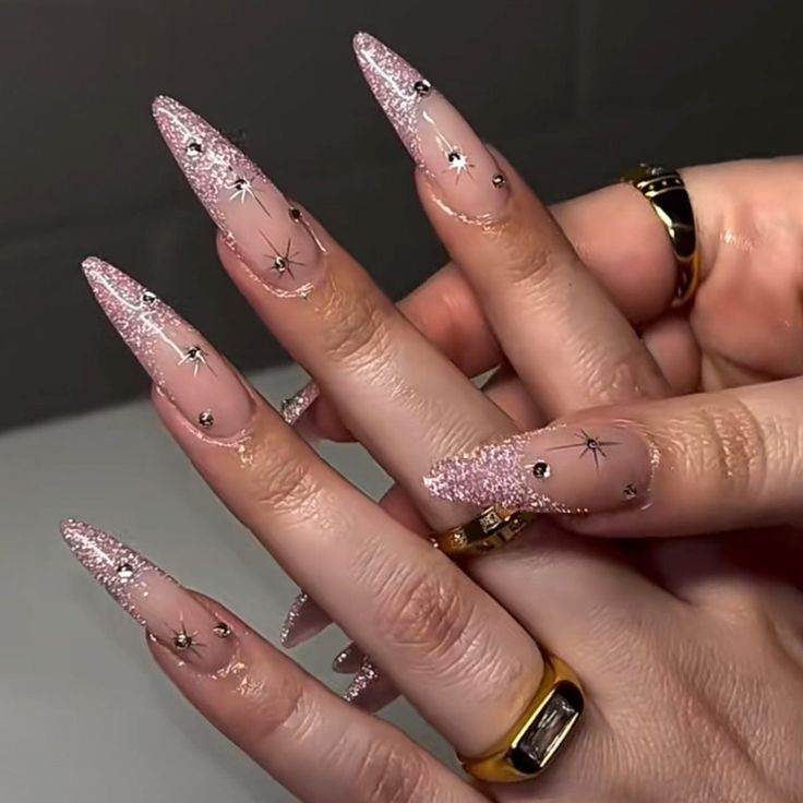 Celestial-Inspired Glittering Stiletto Nails with Soft Pink Base and Star Charms.