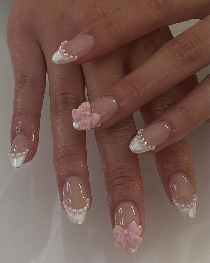 Elegant Pink and White Nail Design with French Tips, Pearls, and Bows