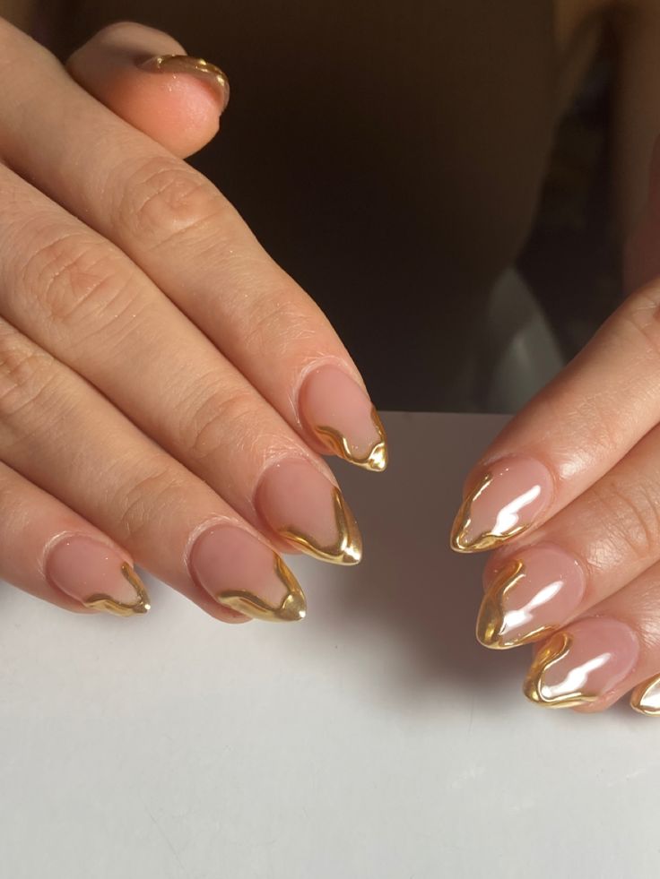 Elegant Stiletto Nails: Nude Base with Striking Gold Tips for a Chic Statement.