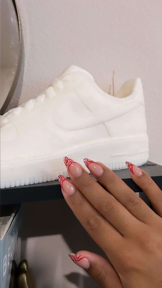 Chic Pink and Red Swirl Nail Design Perfectly Complements Minimalist White Sneakers.