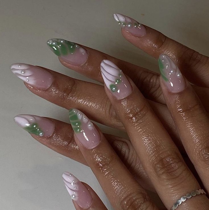 Sophisticated Soft Pink and White Nail Design with Delicate Green Accents and Unique Natural Elements.