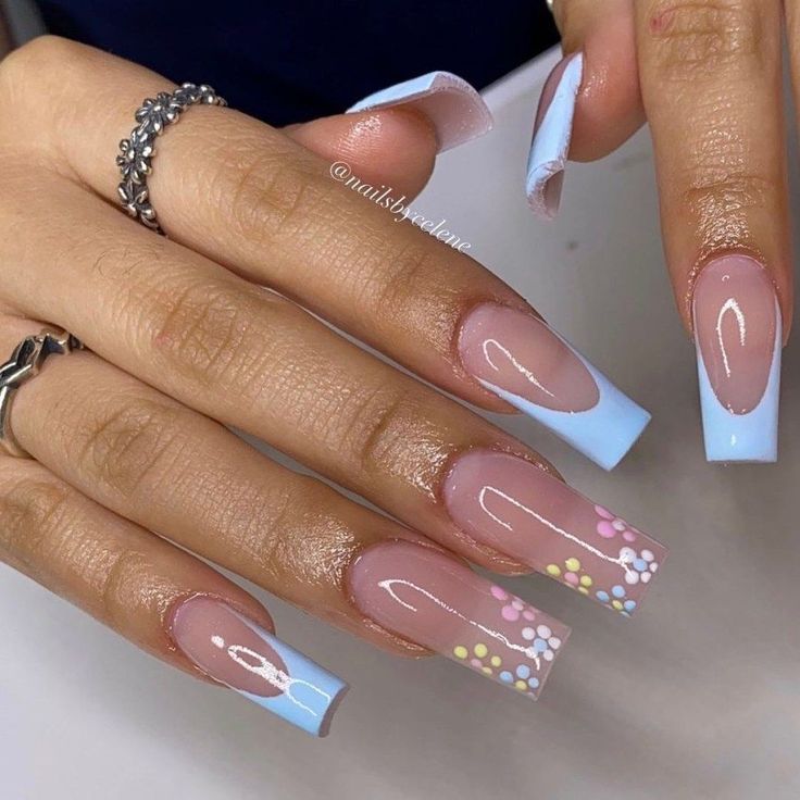 Charming Pastel Nail Design with Soft Pink Base, Blue Tips, and Floral Accents for a Playful Spring Aesthetic.