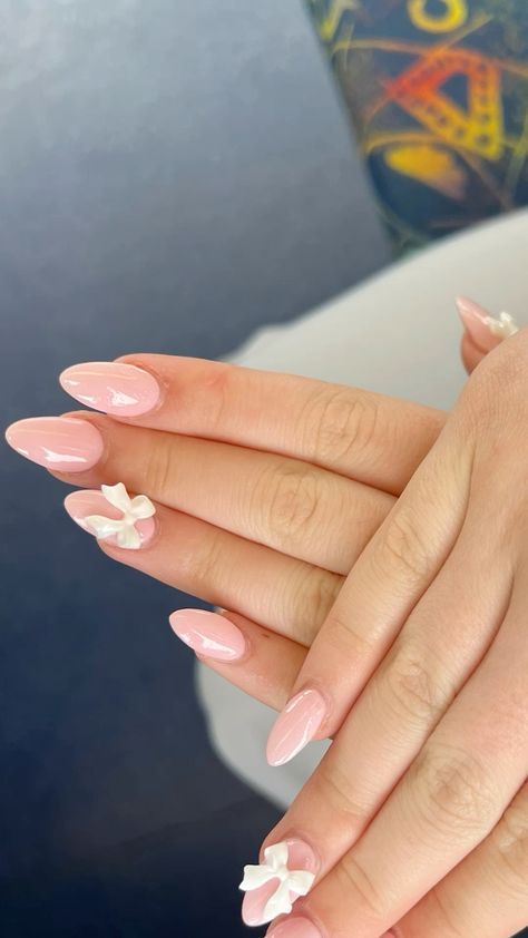 Chic Almond-Shaped Nails with Glossy Blush Pink and Whimsical White Floral Accents.