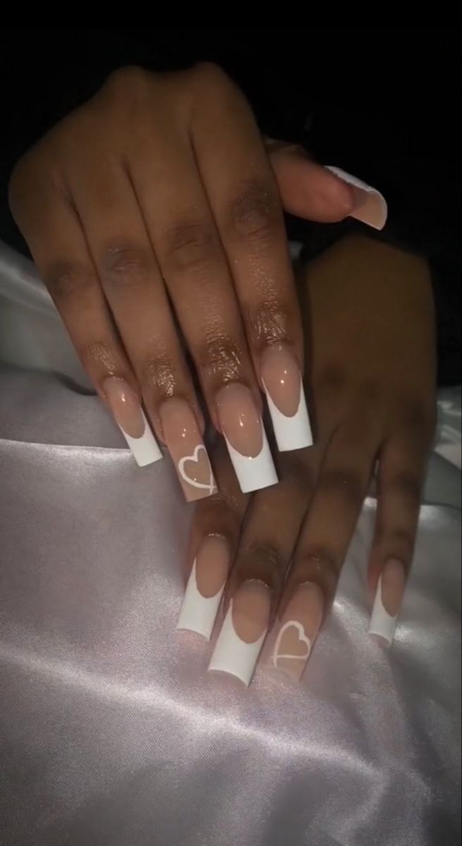 Elegant Long Nails with Nude and White Tips Enhanced by Playful Heart Designs.