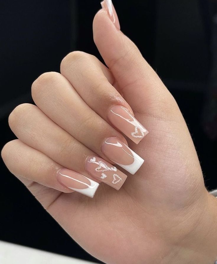 Chic Nude Nail Design with White Tips and Whimsical Heart Patterns