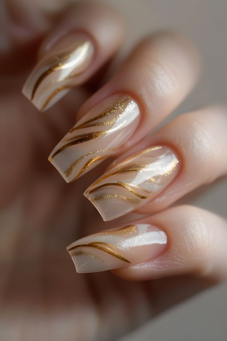 Sophisticated Nail Design: Soft Nude Hues with Shimmering Gold Accents