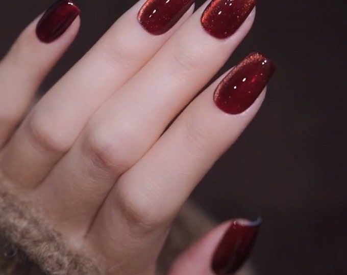 Elegant Glistening Burgundy Nails: A Striking Blend of Glossy and Sparkly Finishes for Any Occasion.