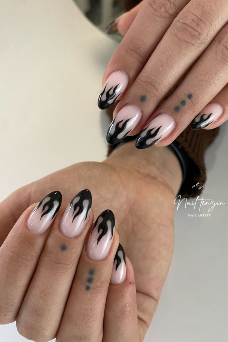 Chic Flame-Inspired Nail Design: Elegant Nude and Bold Black with Eye-Catching Patterns.