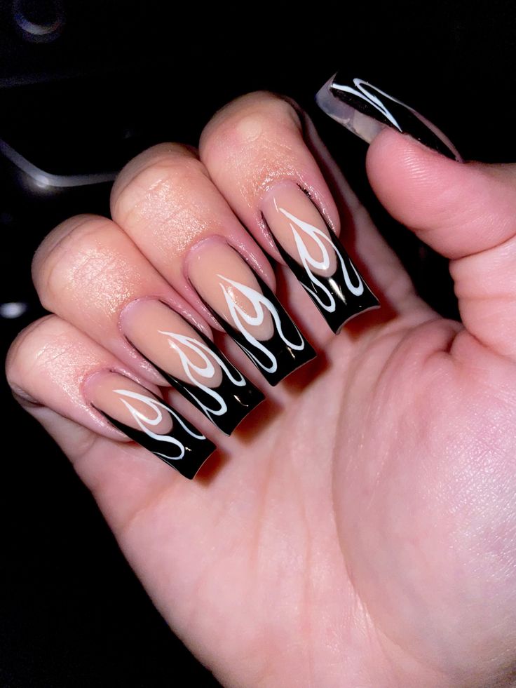 Edgy Flame-Inspired Nail Design with Glossy Black Tips and Intricate White Patterns