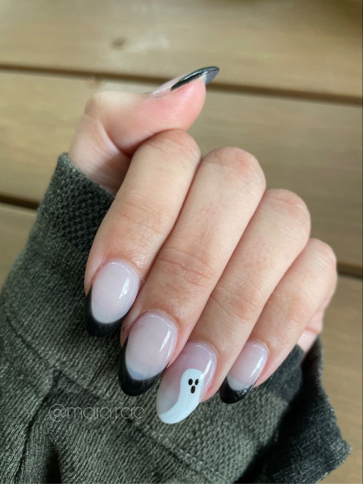 Sophisticated Black and Nude Nail Design with Whimsical Ghost Motif