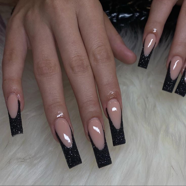 Chic Elegant Nail Design: Bold Black Glitter Tapered Tips on Nude Base.