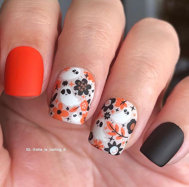 Matte and Glossy Nail Design: Bold Orange and Black Floral-Skull Aesthetic for a Seasonal Edge.