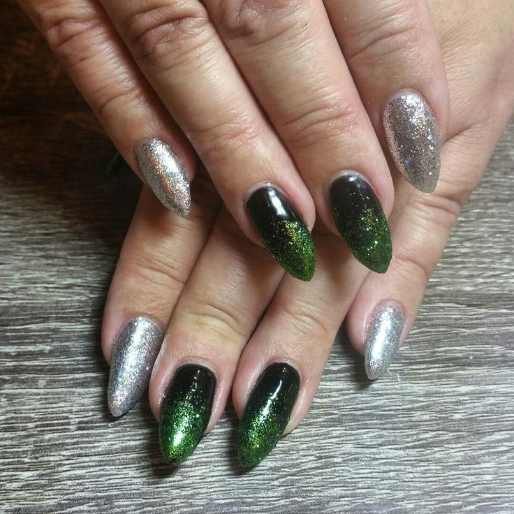 Vibrant Green and Black Nail Design with Shimmering Silver Accents and Glittery Gradient Finish.