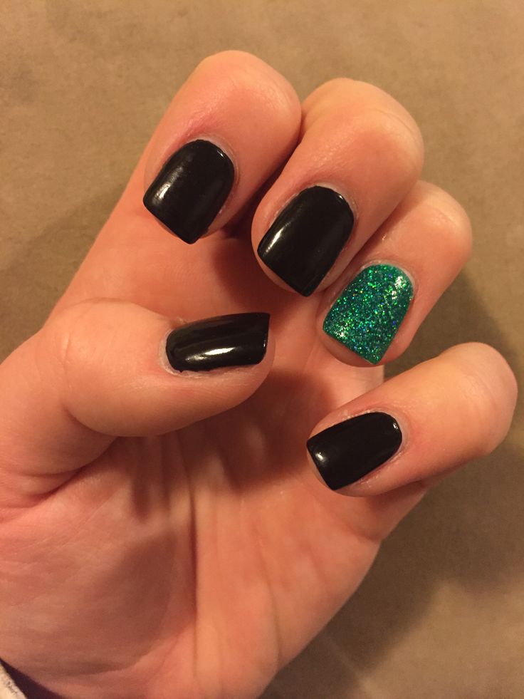 Chic Glossy Black Nails with Sparkly Green Accent: A Perfect Balance of Sophistication and Playfulness.