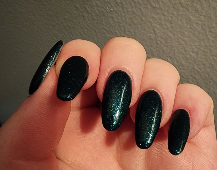 Elegant Dark Green Glitter Almond Nails with Striking Shimmer.