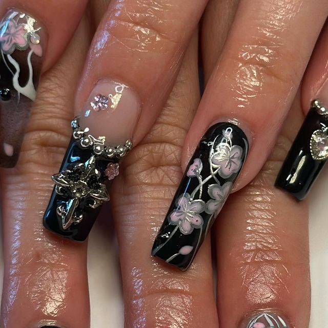 Elegant Black and Floral Nail Design with 3D Metallic Embellishments.