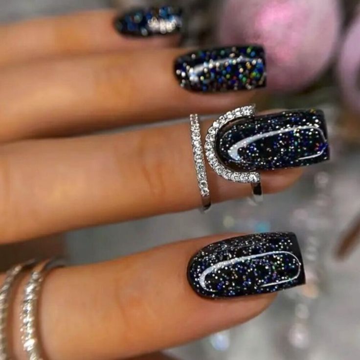 Chic Sparkling Black Nail Design with Elegant White Curves and Silver Accents.