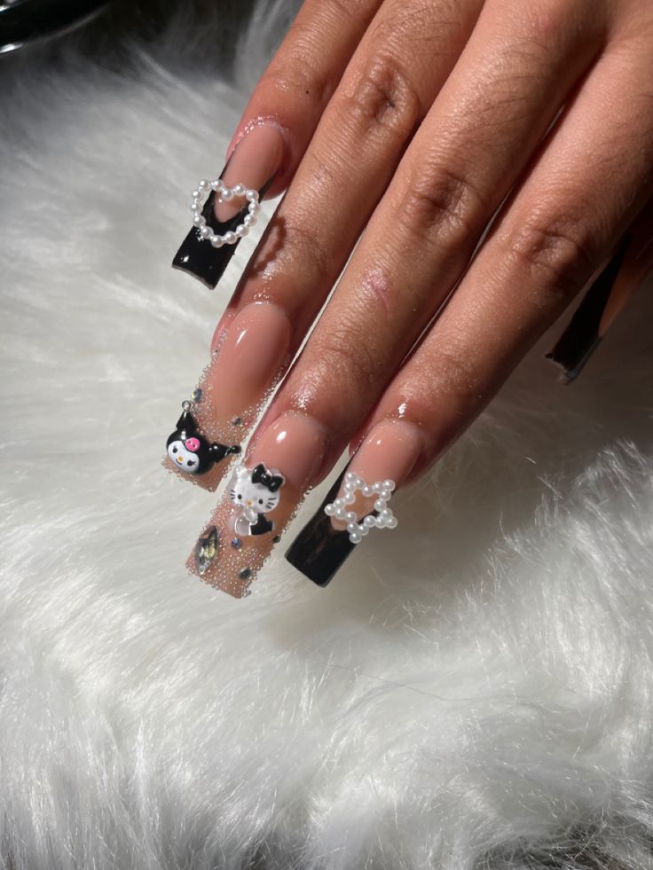 Whimsical Long Square Nail Design with Glossy Black, Translucent Nude, and Cute Embellishments.