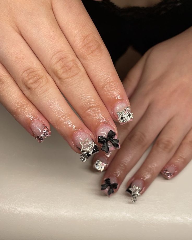 Chic and Playful Elegant Nail Design with Sparkle and Intricate Accessories.