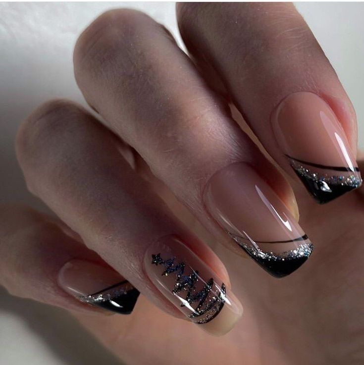 Chic Nude and Black Nail Design with Silver Accents and Unique Patterns.