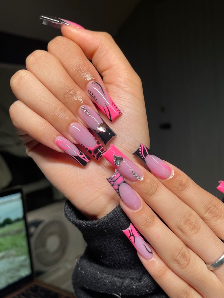 Vibrant Pink and Purple Intricate Nail Design with Bold Patterns and Embellishments.