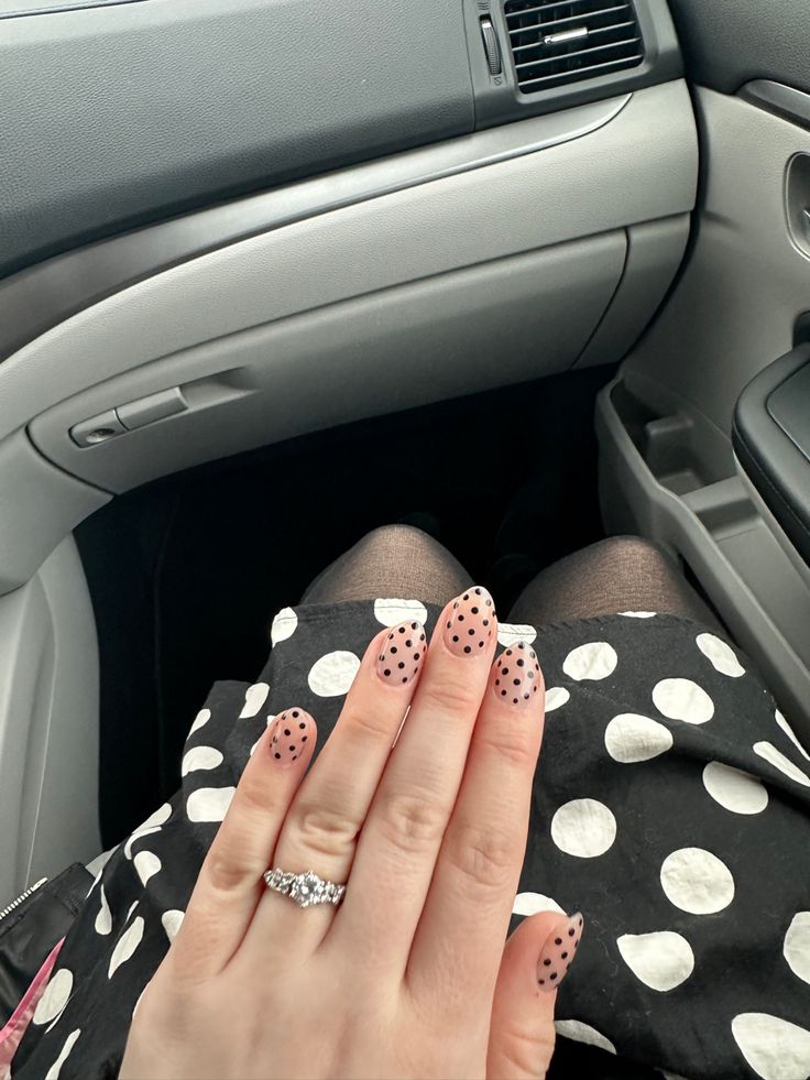 Chic Polka Dot Nail Design with Soft Nude Base and Bold Black Dots for a Stylish Look.