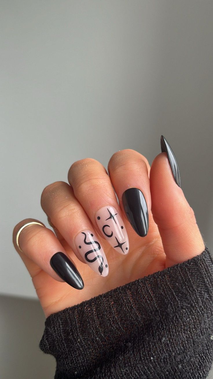 Chic Black and Nude Nail Design with Elegant Pointed Tips and Playful Abstract Patterns.