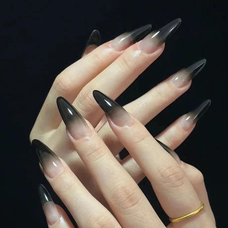 Striking Ombre Stiletto Nails: Translucent Base to Dramatic Black Tips.