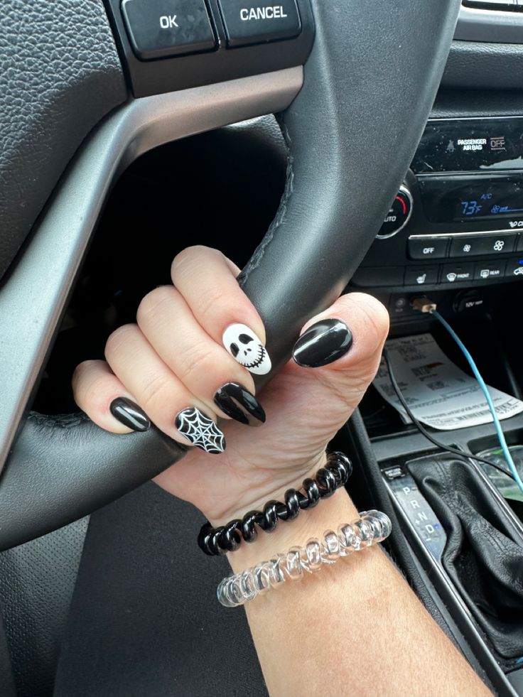 Edgy Black and White Nail Design with Skull and Spider Web Accents for Halloween.