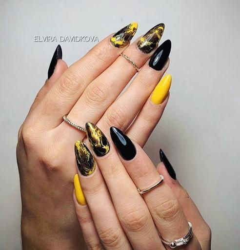 Bold Almond-Shaped Nails in Glossy Black and Vibrant Yellow with Elegant Silver Accents.