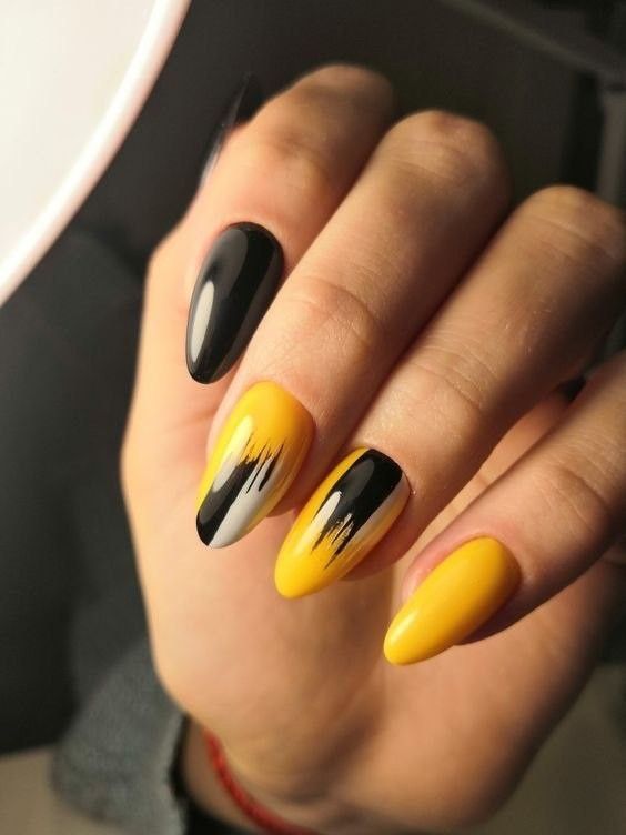 Dynamic Yellow and Black Nail Design with Unique Patterns and Textures.