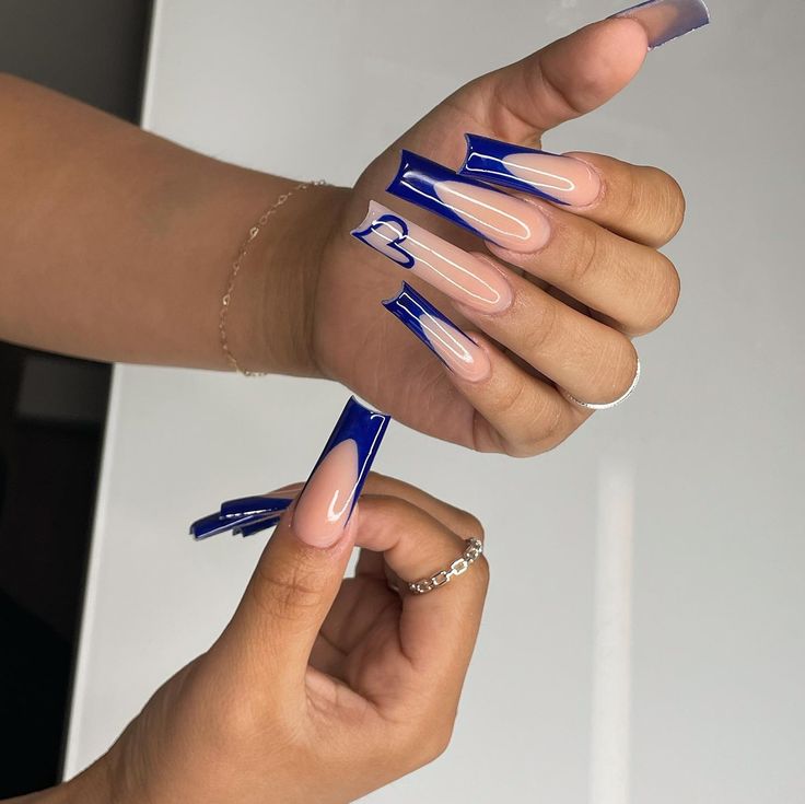 Elegant Bold Blue and Nude Nail Design with Heart Accent.