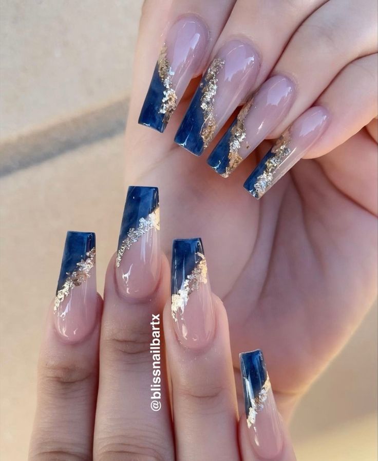 Sophisticated Nail Design: Deep Blue and Nude Shades with Striking Gold Accents.