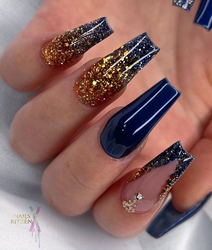 Elegant Navy Blue Nail Design with Gold Glitter Accents and Gemstone Embellishment.