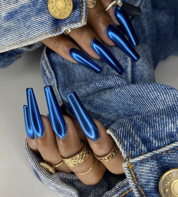 Elegant Striking Blue Stiletto Nails Accentuated by Glossy Finish and Delicate Gold Rings.