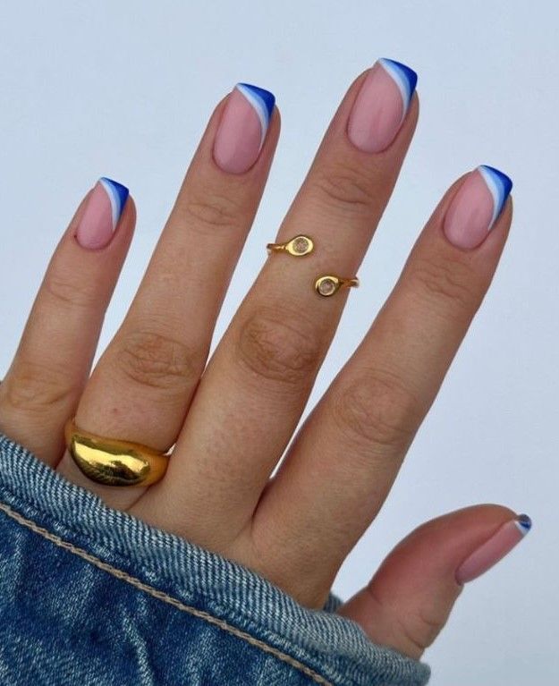 Chic French Manicure with Vibrant Blue Tips and Elegant Gold Accents.