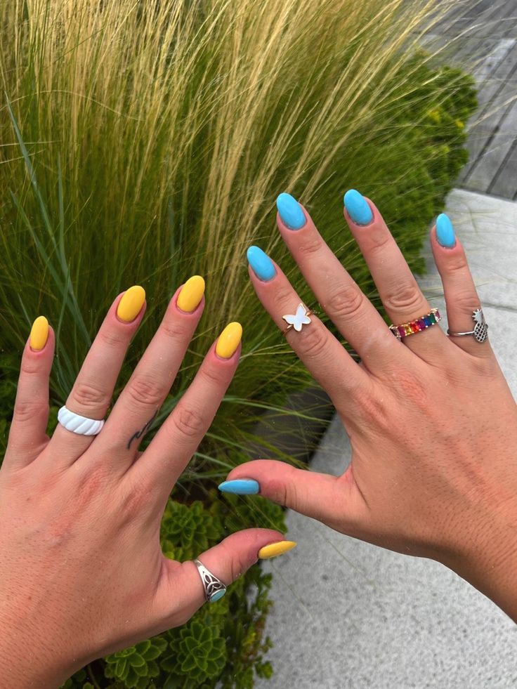 Playful Summer Nail Design in Soft Yellow and Serene Blue with Stylish Rings.