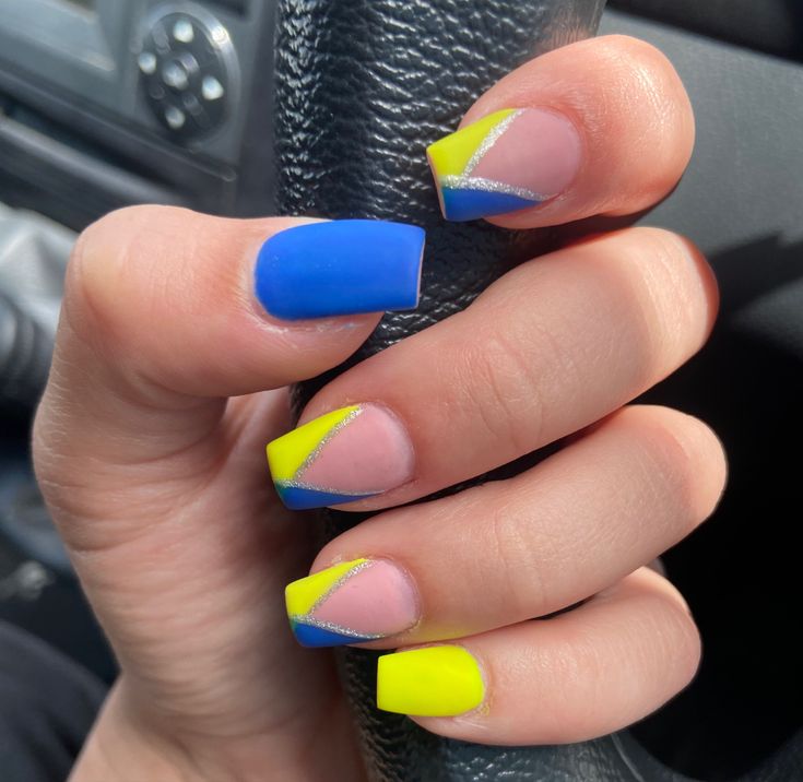 Vibrant Blue and Neon Yellow Bold Nail Design with Geometric Shapes and Silver Stripes.