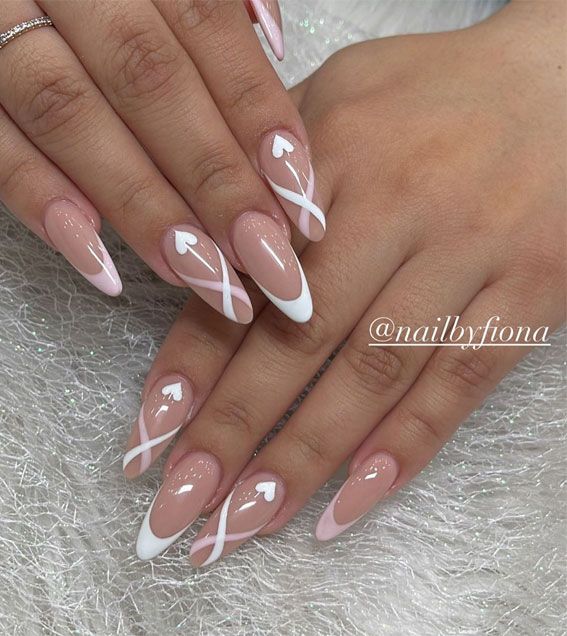 Chic Nude Nail Design with White French Tips and Heart Accents.