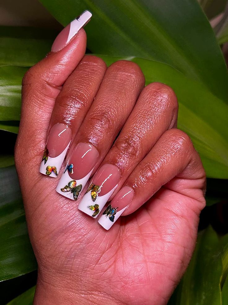 Whimsical Elegant Nail Design: Nude & White Tips with Hand-Painted Vibrant Butterfly Embellishments.