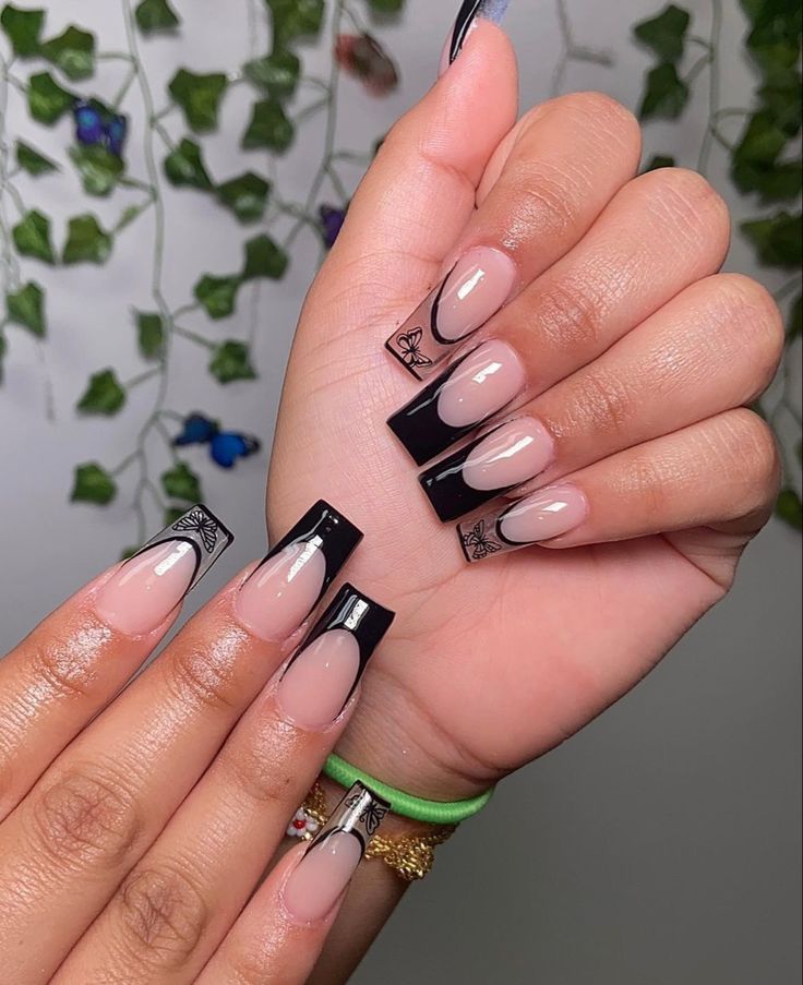 Sophisticated Elegance: Modern Nude and Glossy Black French Nail Design with Intricate Patterns.