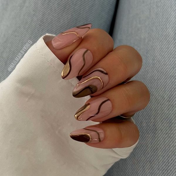 Elegant Nails: Soft Pinks and Rich Browns with Gold Accents for a Modern Look.